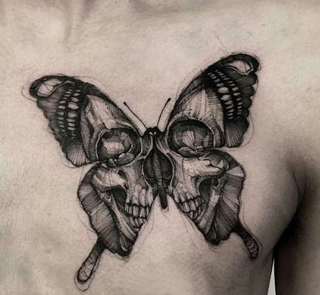 Dark and detailed black and grey butterfly tattoo on the chest, featuring skulls within the wings, symbolizing duality and transformation.