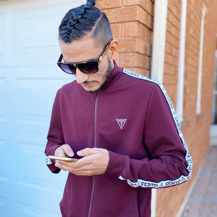 A Classic Braided Hairstyle For Men Featuring Top Braid, Ponytail, And Shaved Sides And Back