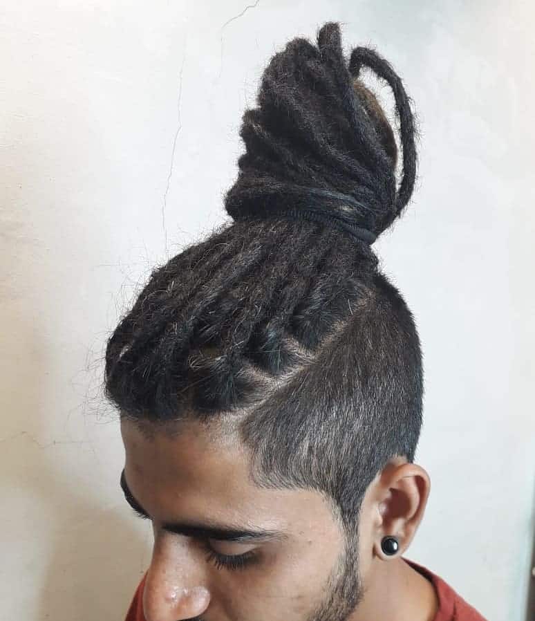 A Man Bun Hairstyle Paired With Undercut And Dreads