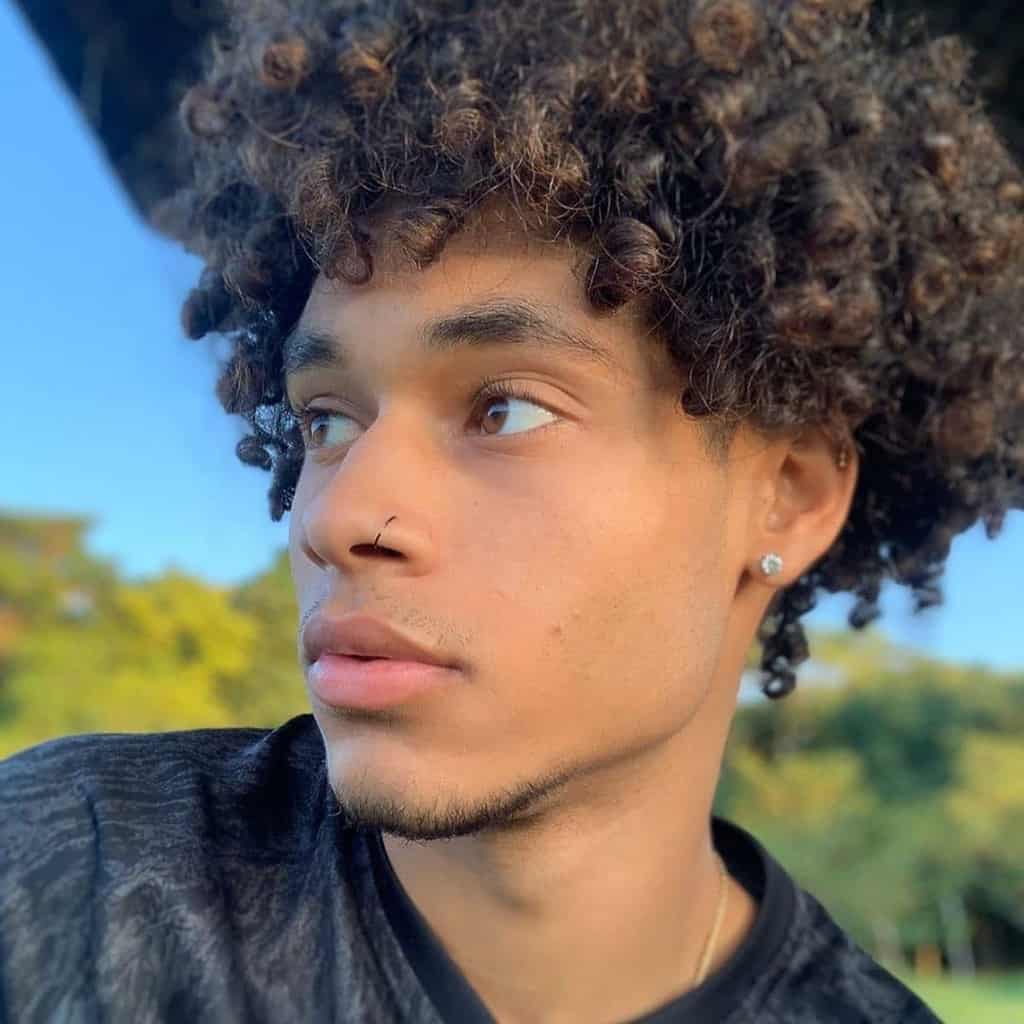 A Man Wearing Jewfro With Medium Length Wild Curls