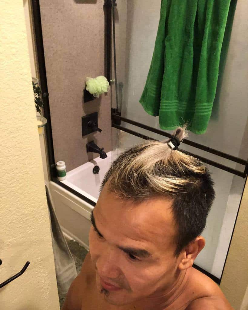 A Man Wearing A Man Bun Undercut On Short Hair