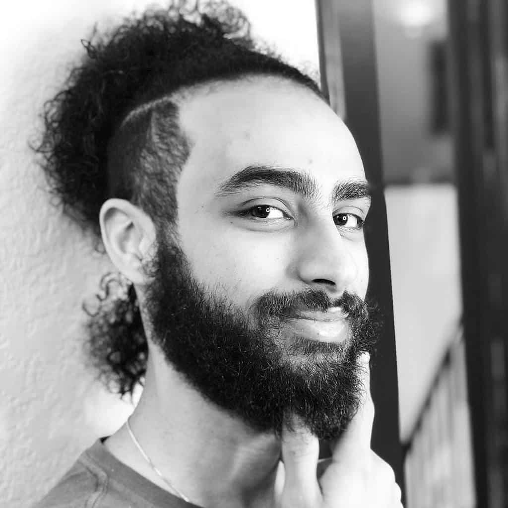 A Man Wearing A Messy Bun Paired With An Undercut. This Is One Of The Most Effortless Man Buns Undercut To Create