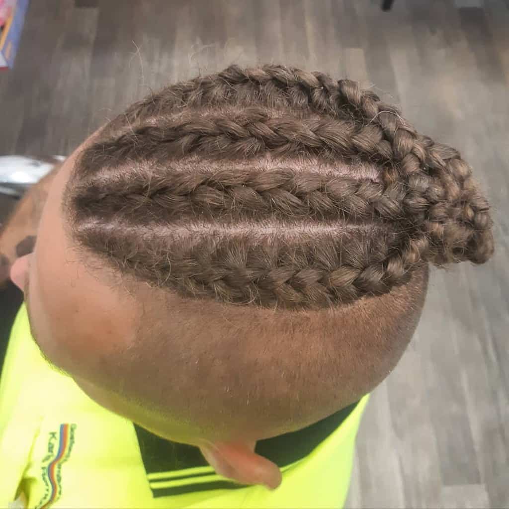 A Man Wearing Braided Hairstyle With A Man Bun And Undercut