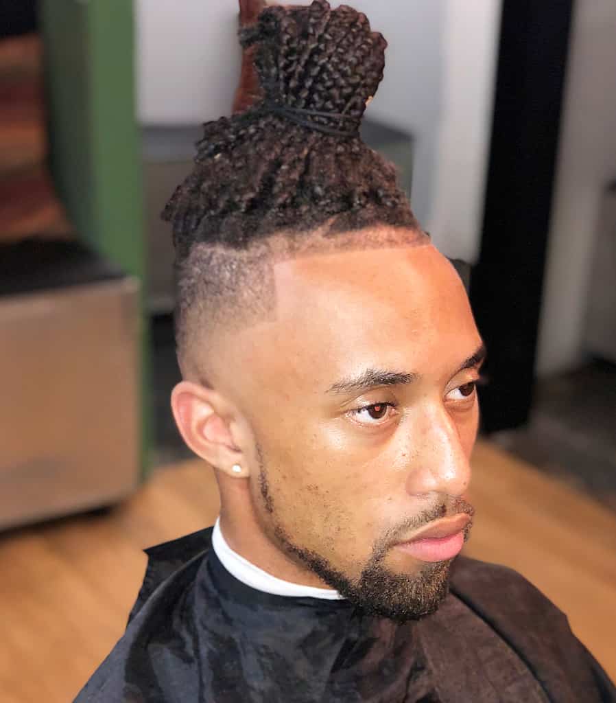 A Man With Braided Bun Paired With A Low Undercut