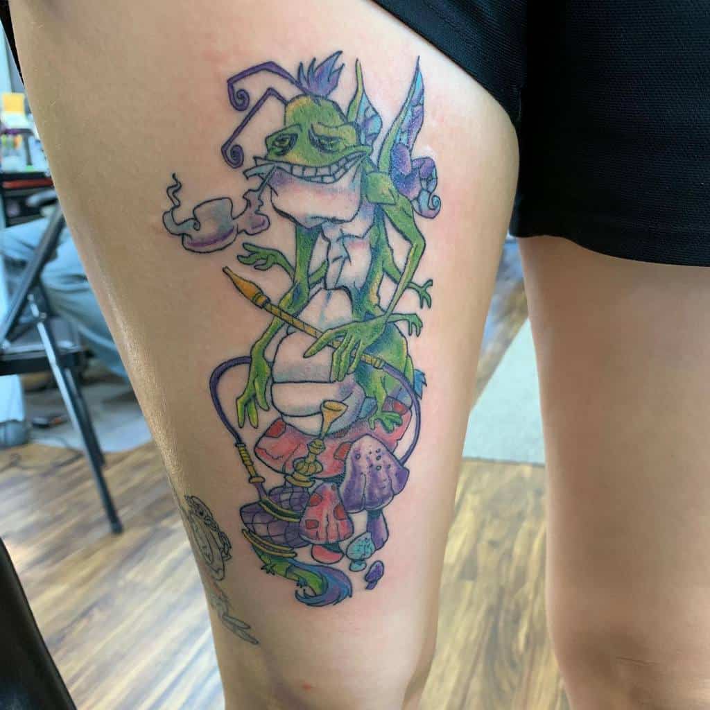 Colorful tattoo of a character from Alice in Wonderland, sitting on mushrooms with a hookah, surrounded by vibrant colors