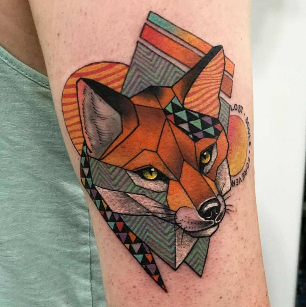Geometric fox tattoo featuring vibrant patterns and colors on an upper arm