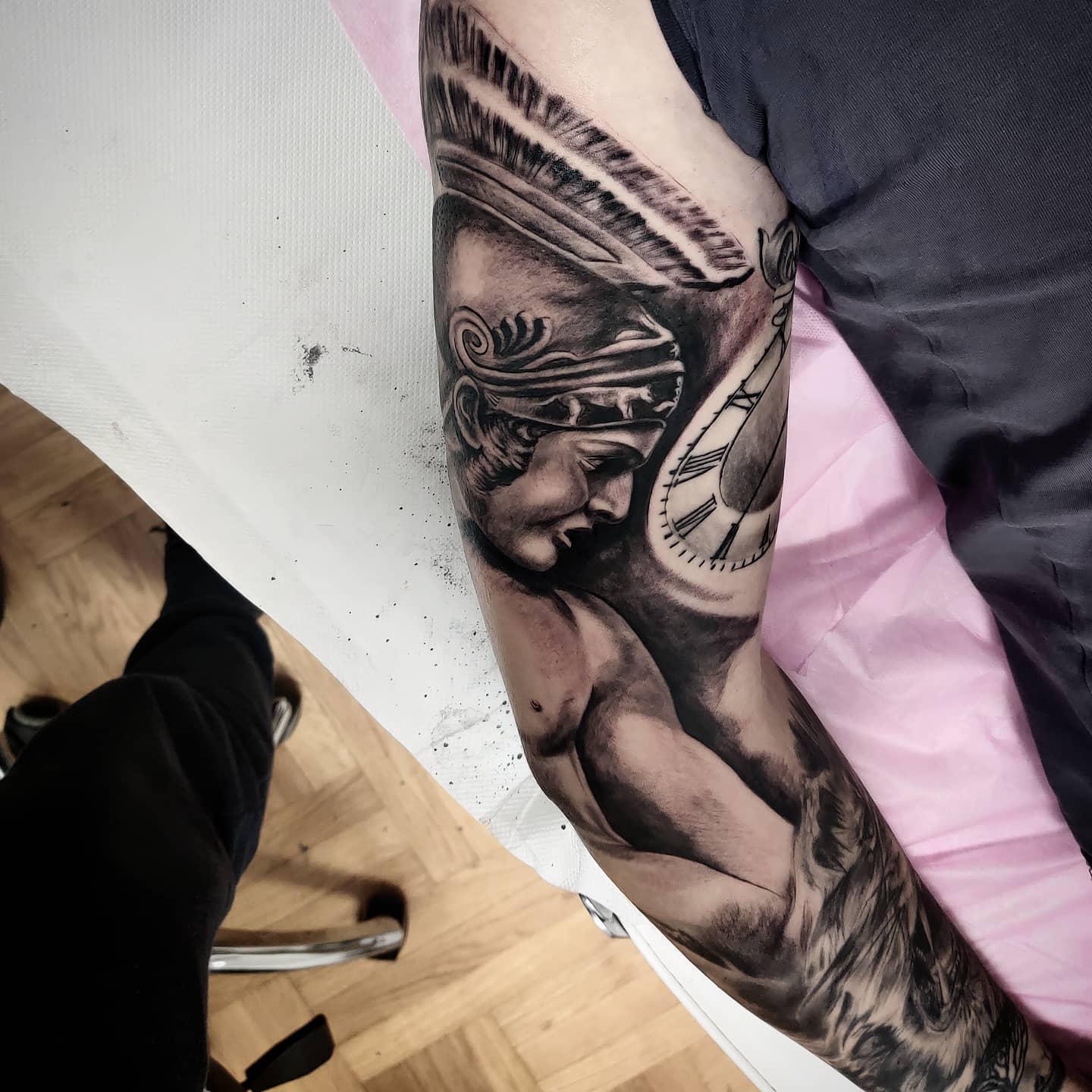 Black and white tattoo of Achilles with a headdress on an arm