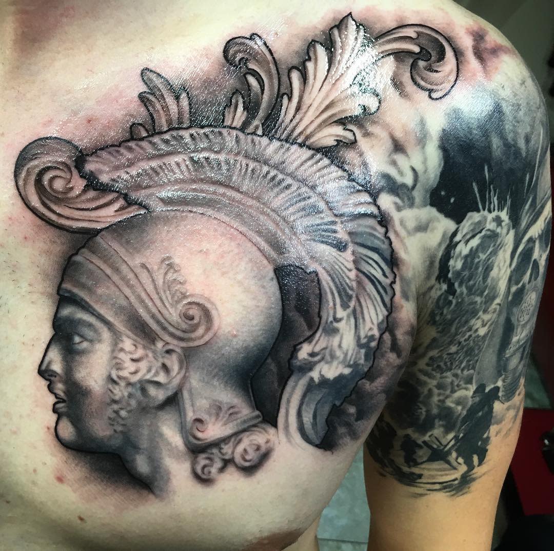 Tattoo of a detailed Achilles with helmet and plume on a chest and shoulder