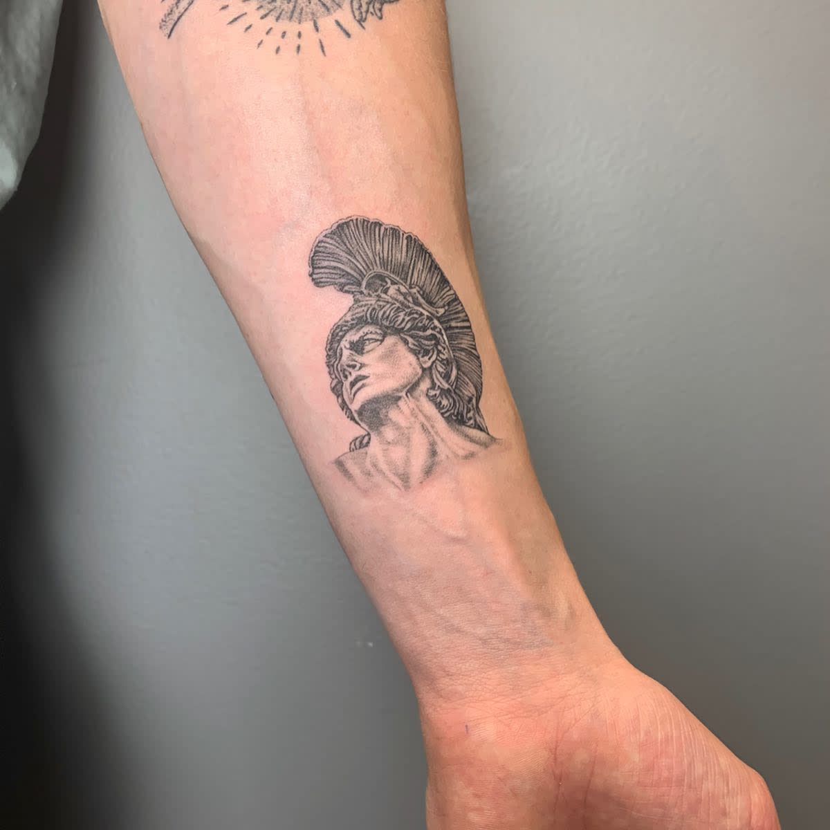 Forearm tattoo of Achilles wearing a plume helmet