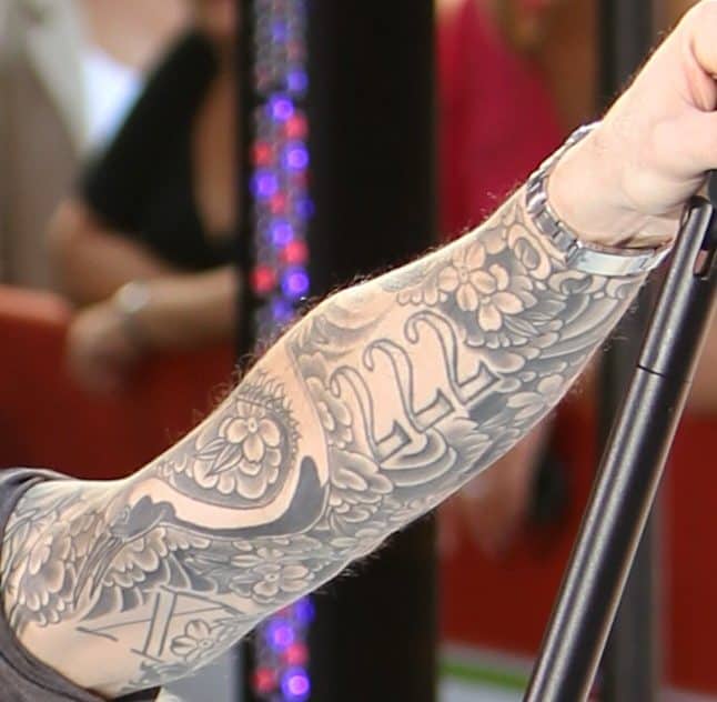 Adam Levine's detailed black and gray tattoos, including floral patterns and numbers '222' with duck and 'X'