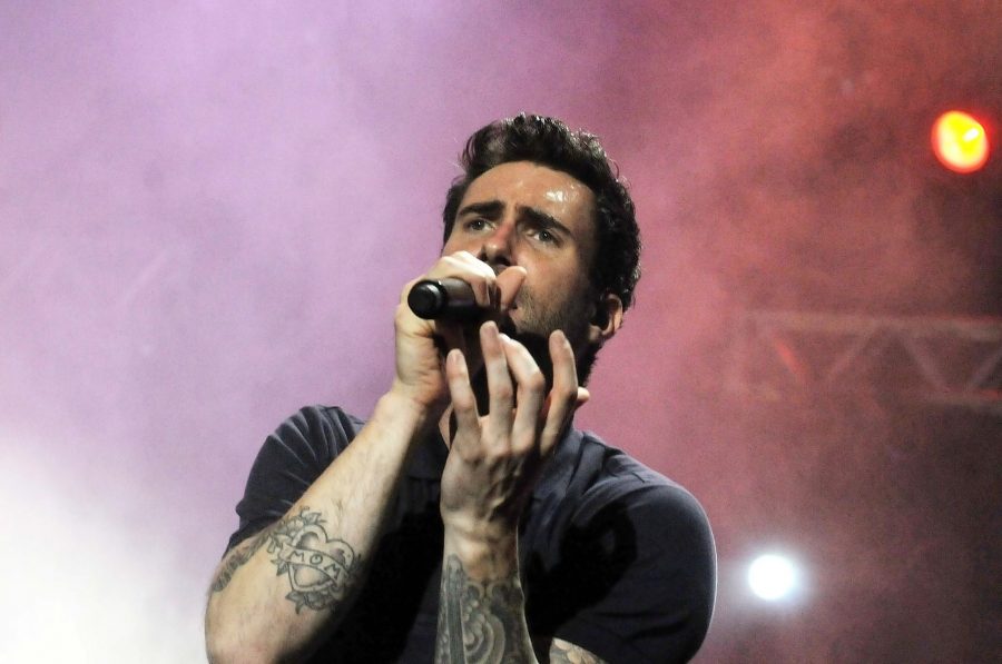 Adam Levine's tattoo featuring a heart with a 'MOM' banner on it surrounded by flowers