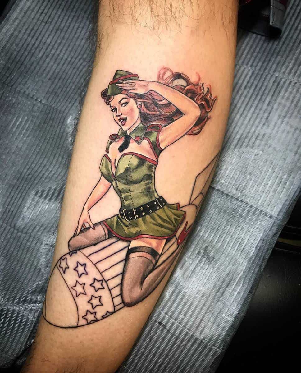 A tattoo of a pin-up girl in a military outfit sitting on a bomb with a star pattern