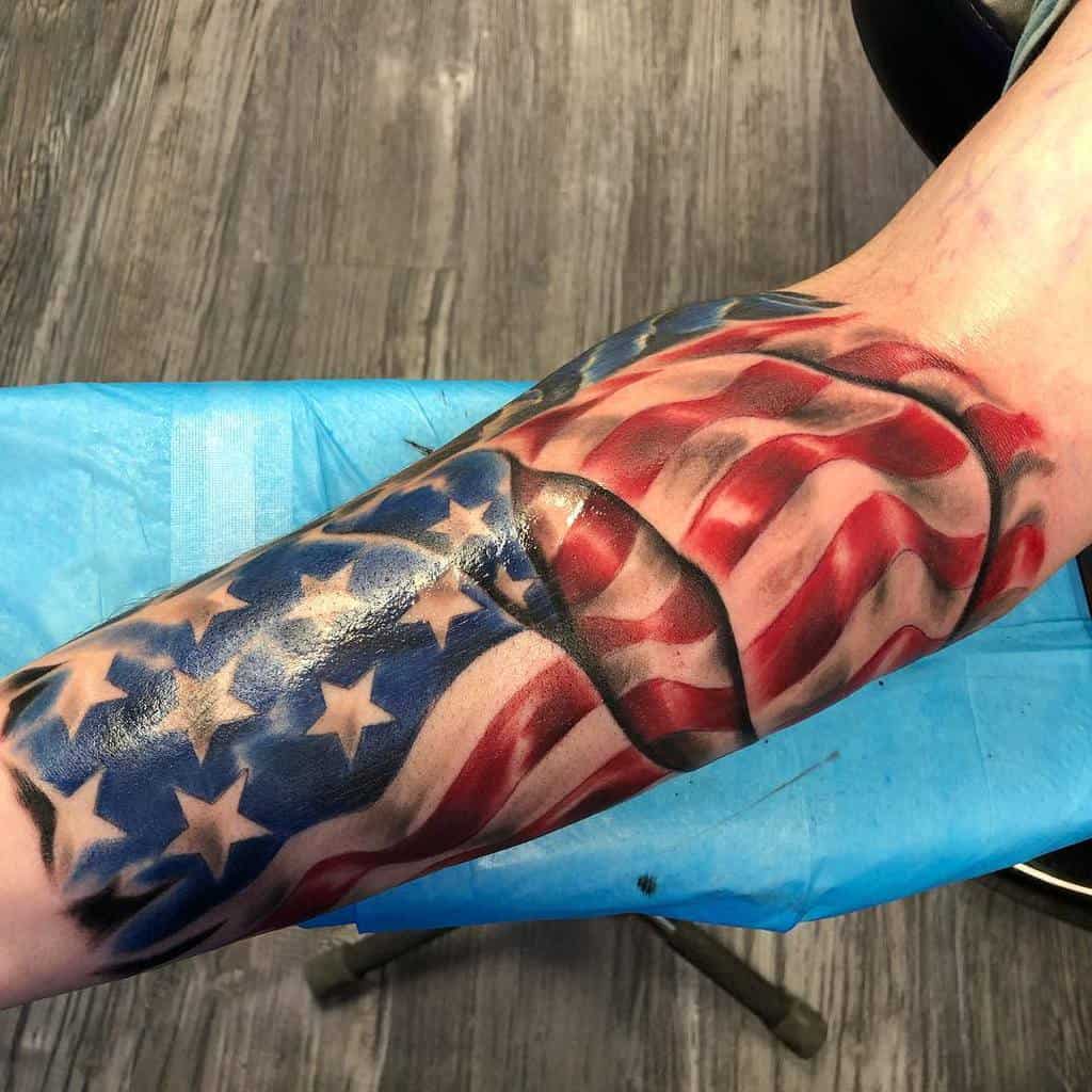 Tattoo of an American flag on a forearm with wrinkles and shadows