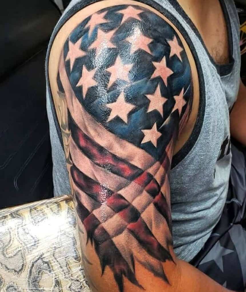 A tattoo of the American flag with stars and stripes on a man's upper arm