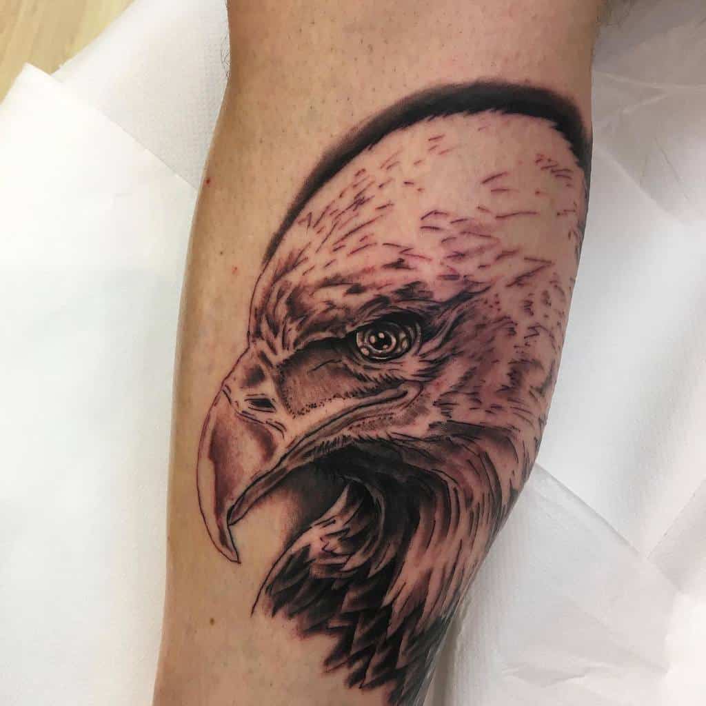 Tattoo of a detailed eagle's head on a forearm with shading and fine lines