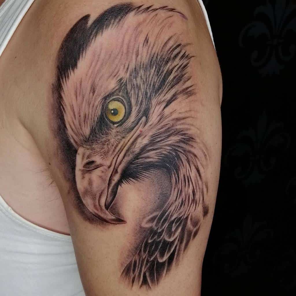 A realistic eagle tattoo on an upper arm, showcasing intricate details and shading