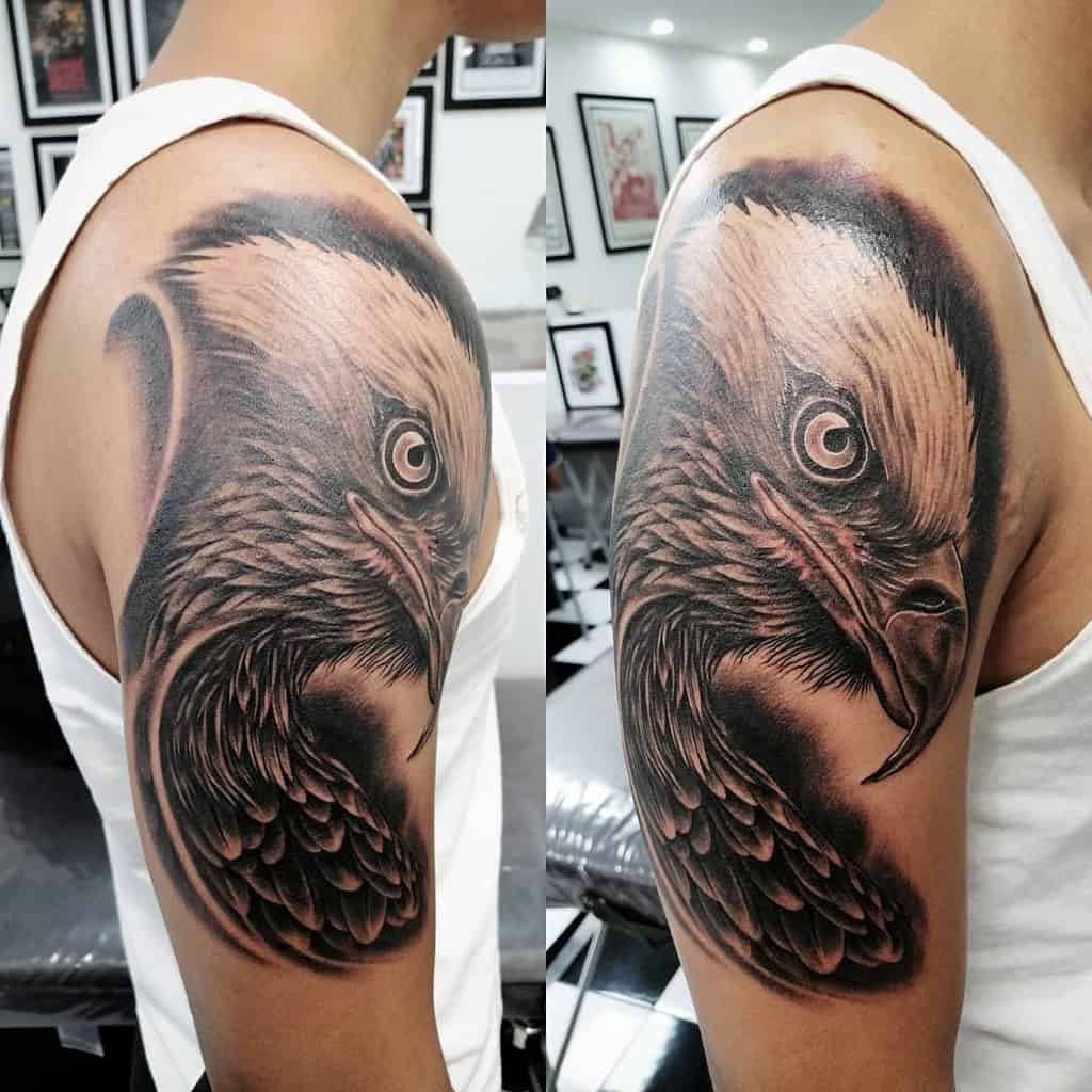 Showing a detailed eagle head tattoo on the upper arm