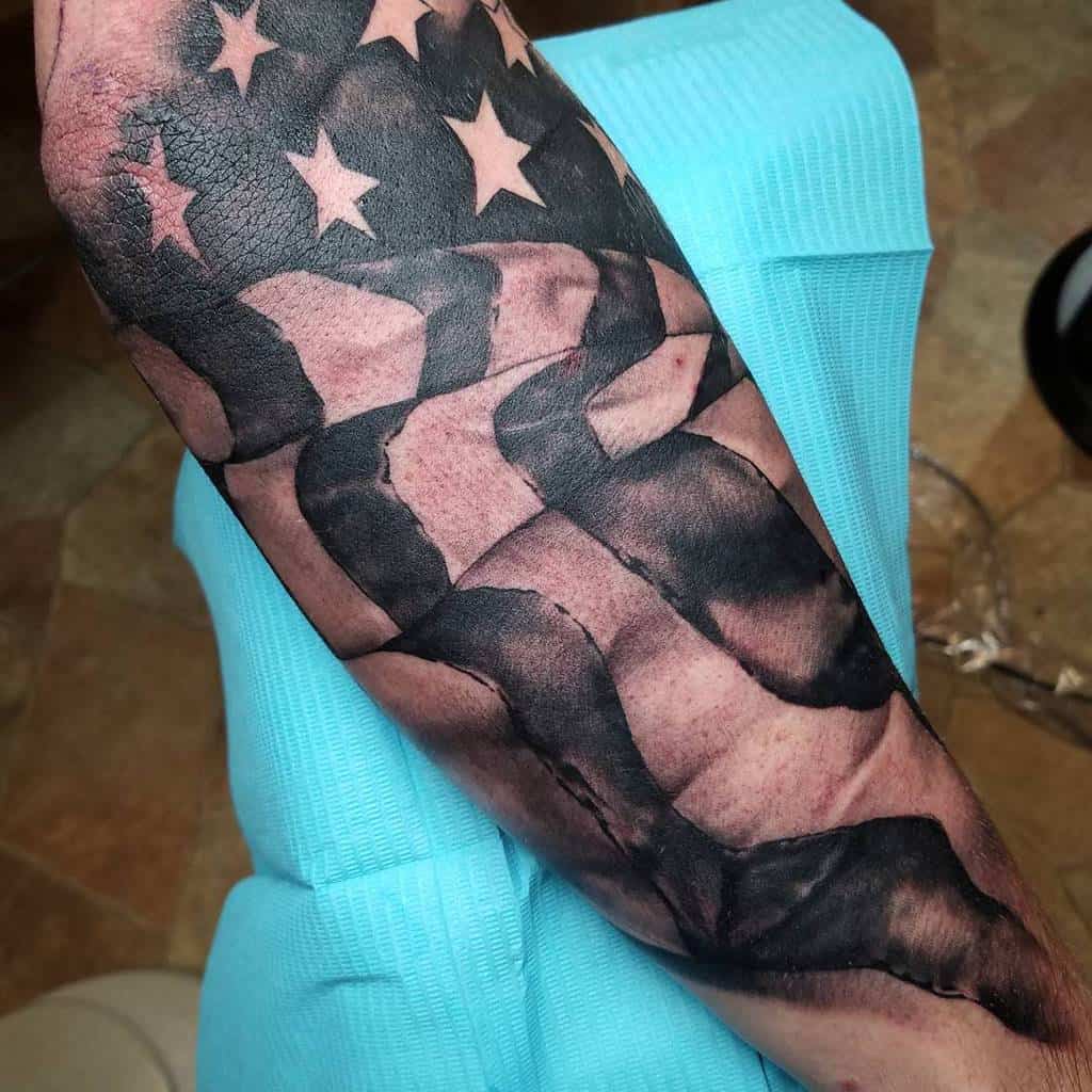 Arm tattoo of a stylized American flag in black ink