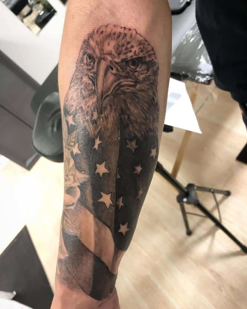 Tattoo of an eagle with an American flag on a man's forearm