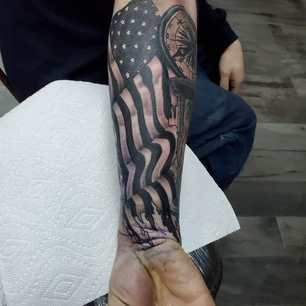 Forearm tattoo of a stylized American flag and clock