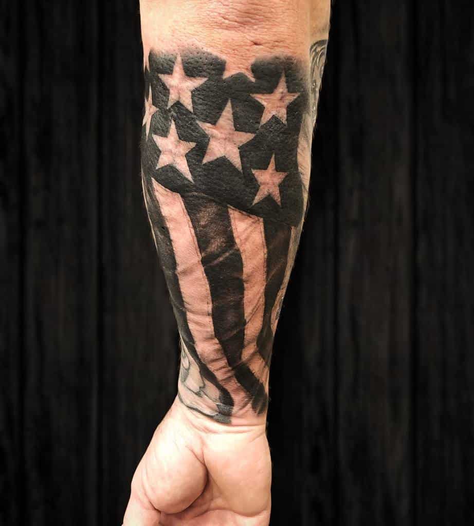 Forearm tattoo of an American flag with stars and stripes