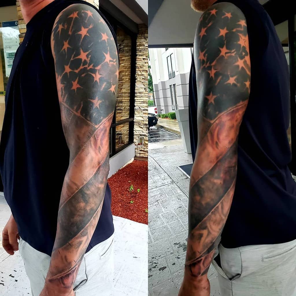 A man with an American flag sleeve tattoo on his arm