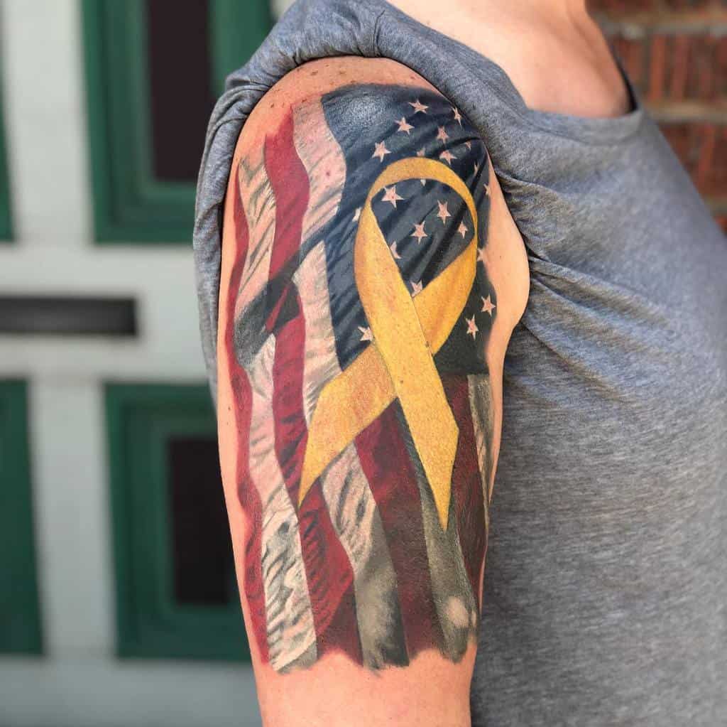 Arm tattoo of U.S. flag with a yellow ribbon overlay