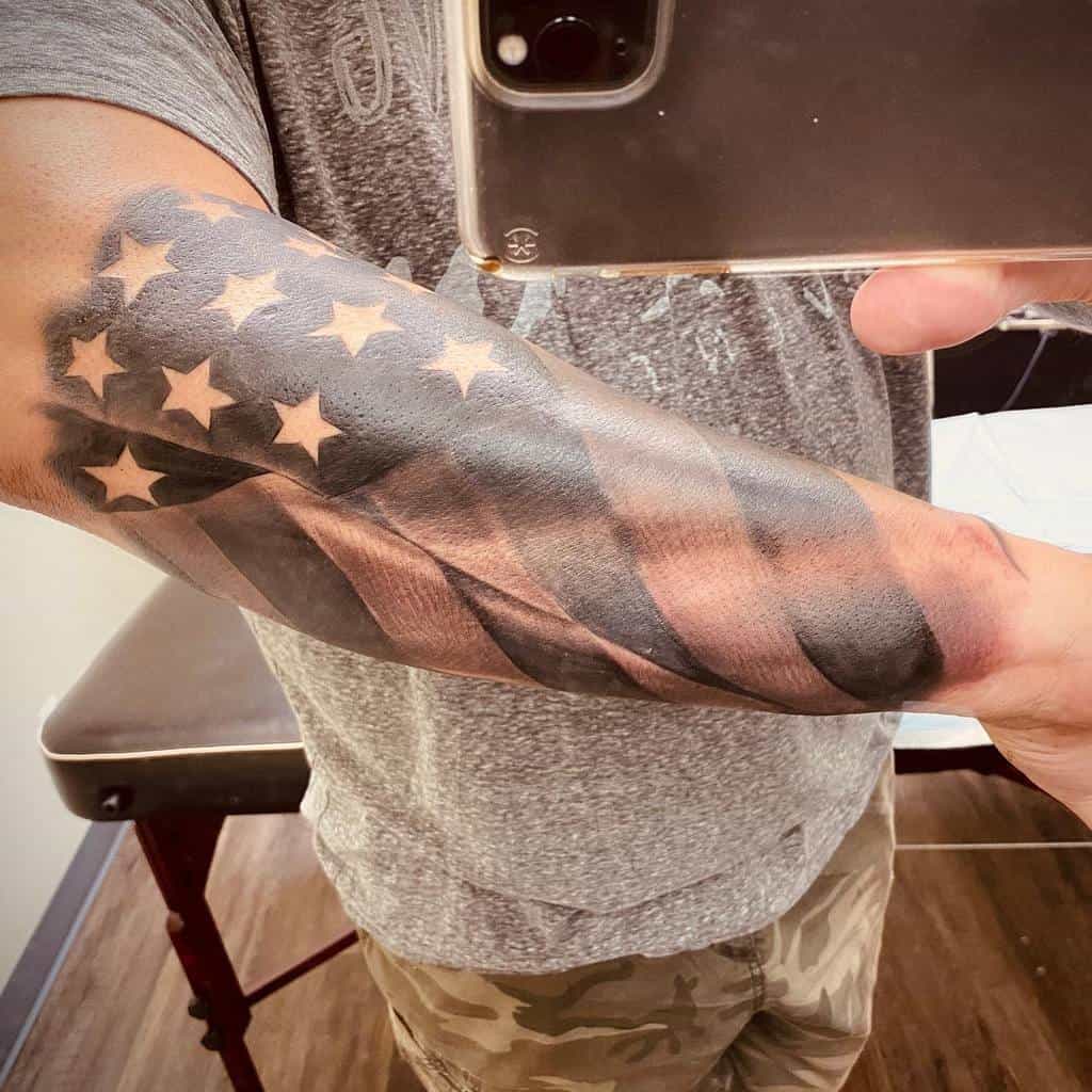 Forearm tattoo of an American flag with stars and stripes