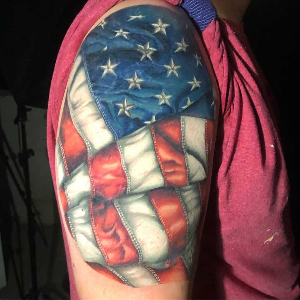 Arm tattoo of the American flag with a 3D illusion, showing stars and stripes