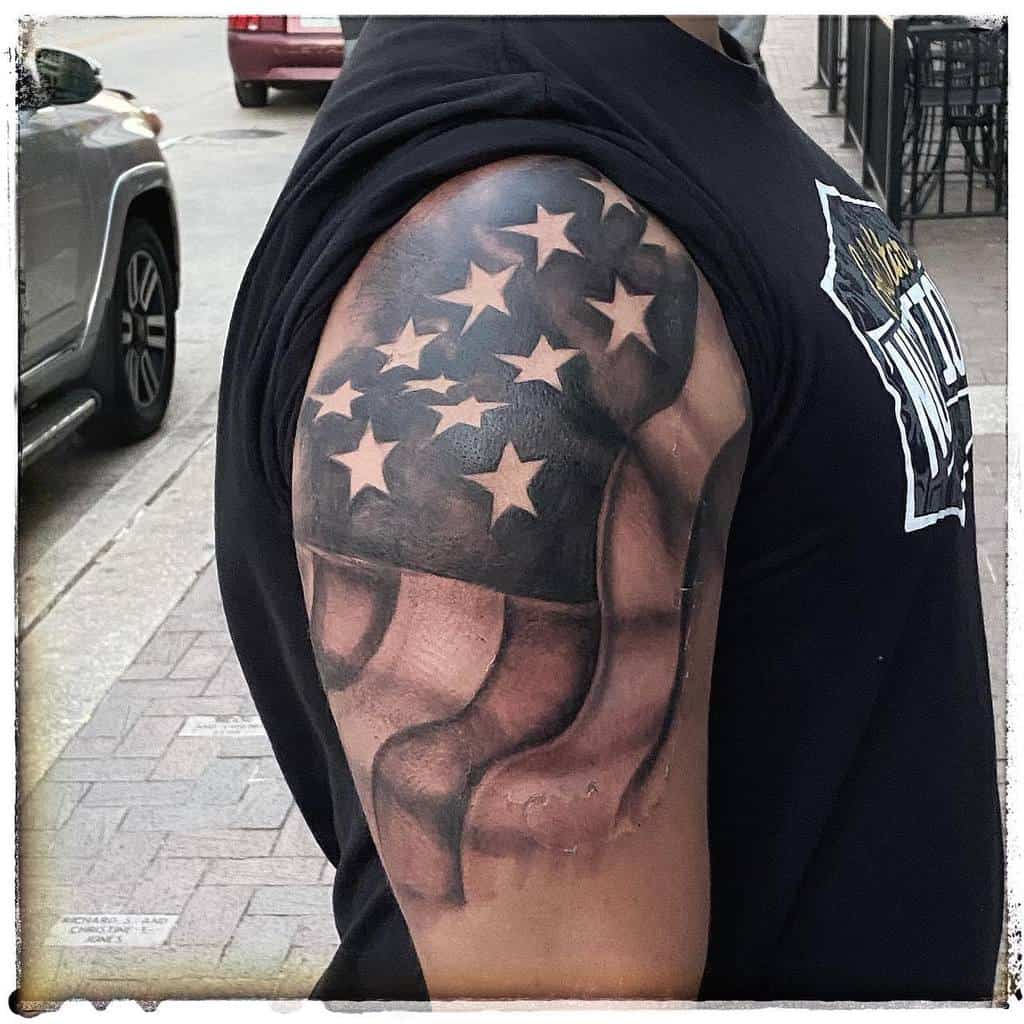 Arm tattoo of an American flag with stars and stripes