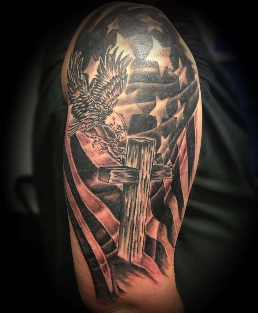 Tattoo of an eagle, cross, and American flag on an upper arm
