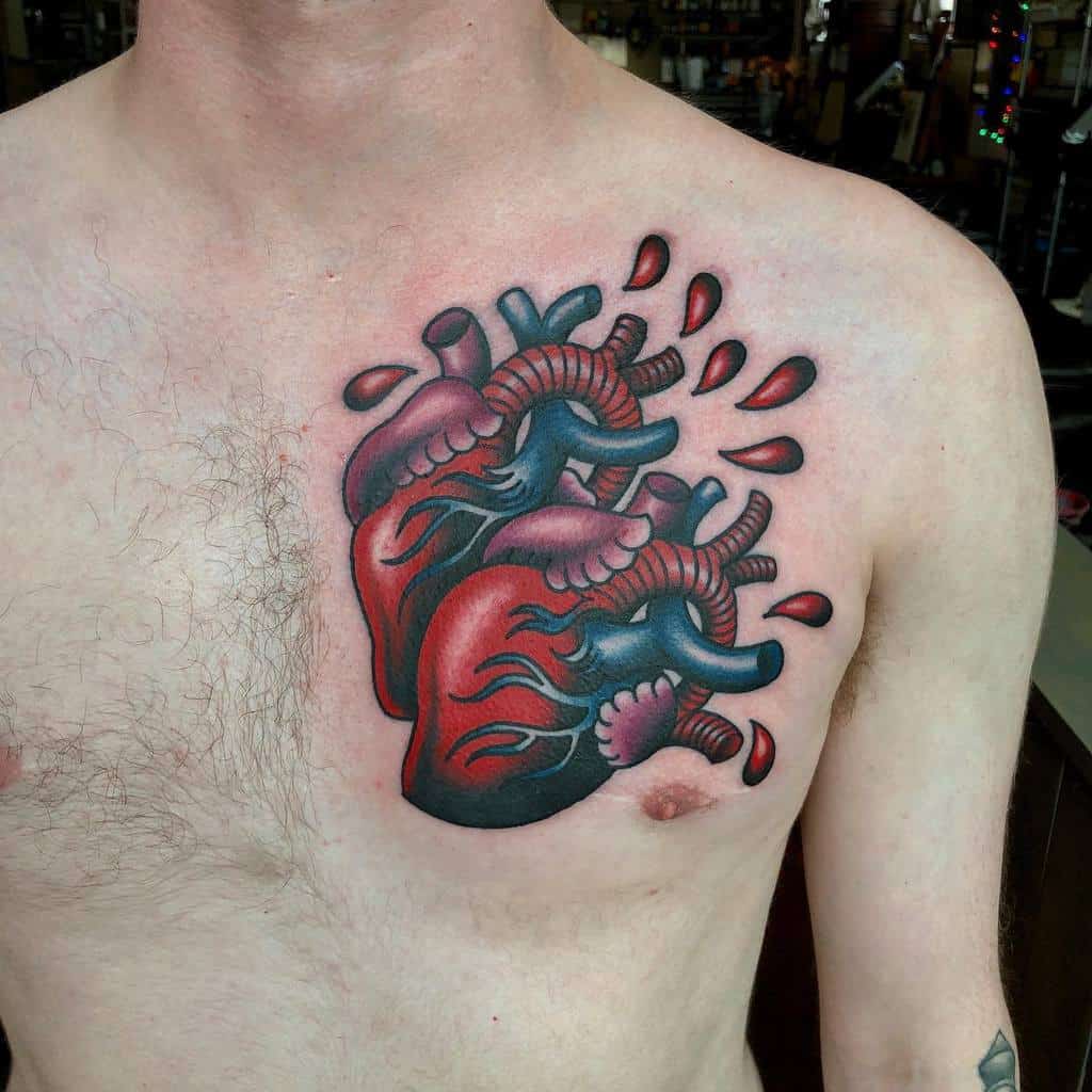 Bold, colorful tattoo of an anatomical heart on the chest, featuring vibrant red and blue tones with dripping blood details