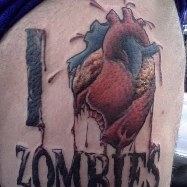 Tattoo of the words "I love zombies" with a bleeding anatomical heart replacing the word "love