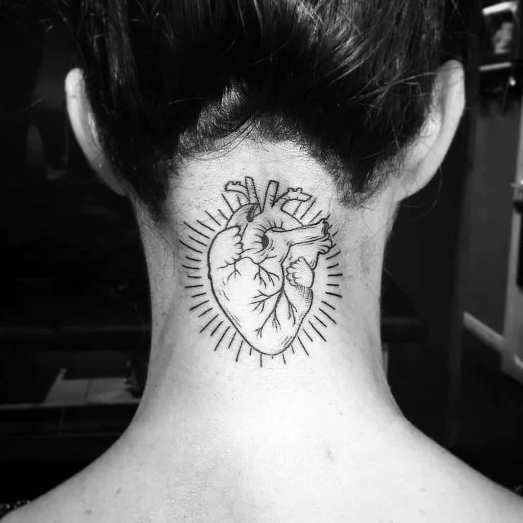 Black and white anatomical heart tattoo surrounded by radiating lines