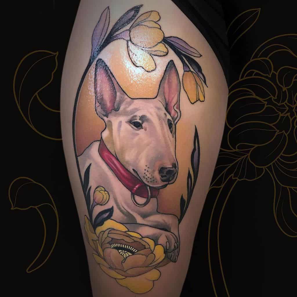 Art Nouveau-style tattoo of a bull terrier with a red collar, surrounded by elegant yellow flowers, leaves, yellow background and curved ornamental lines