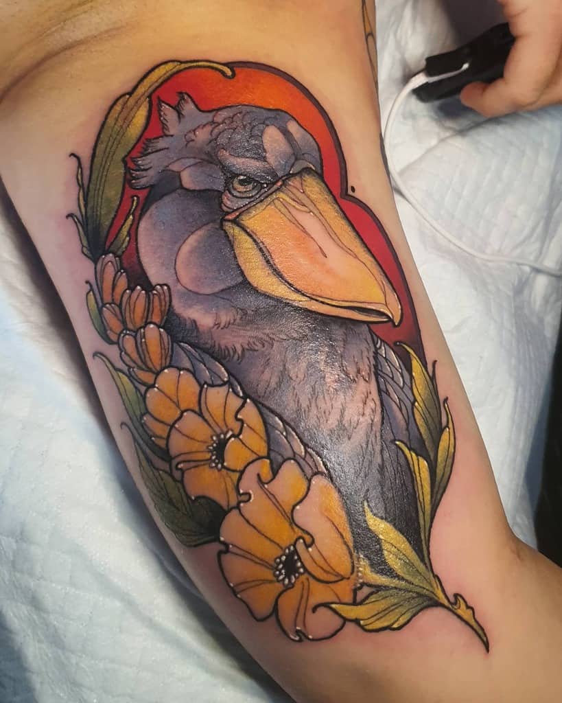 Art Nouveau-style tattoo of a majestic shoebill stork with intricate floral accents, flowing leaves, and a warm red-orange backdrop