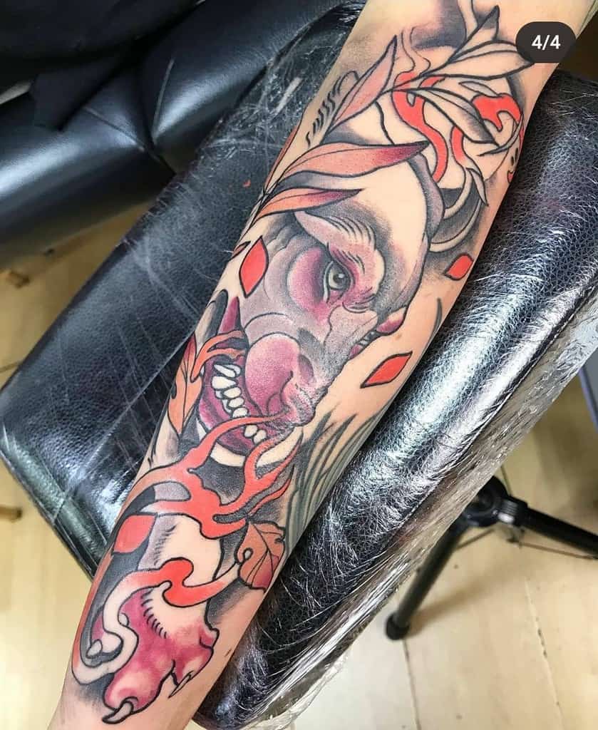 Art Nouveau-style tattoo sleeve featuring a fierce wolf with flowing ornamental designs, red accents, leaves, grass and swirling organic patterns