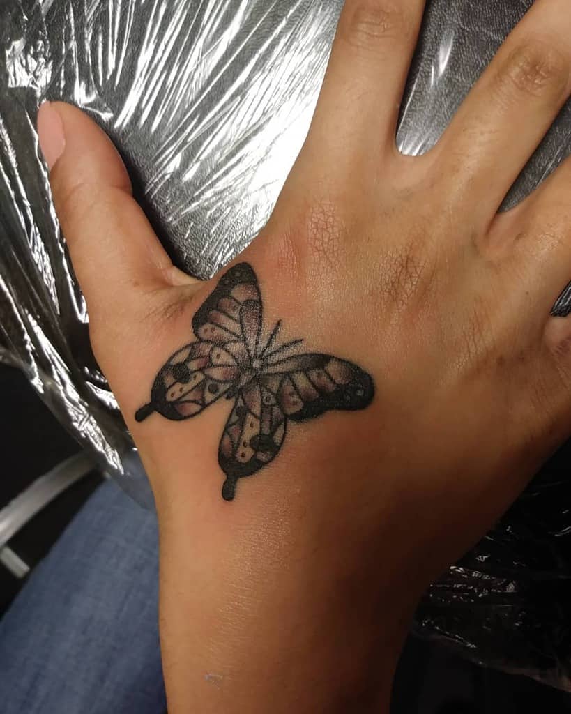 Delicate butterfly tattoo featuring intricate shading and fine details