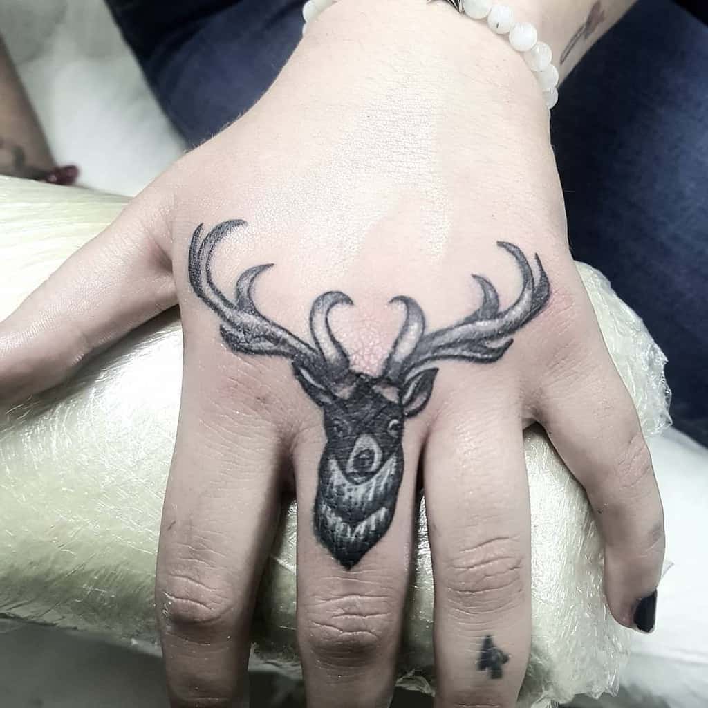 Black and grey deer head tattoo with antlers