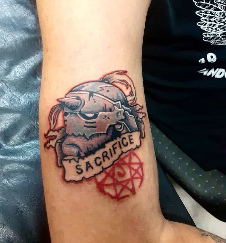 Fullmetal Alchemist tattoo of Alphonse Elric’s armored head with a "Sacrifice" banner and red transmutation circle below