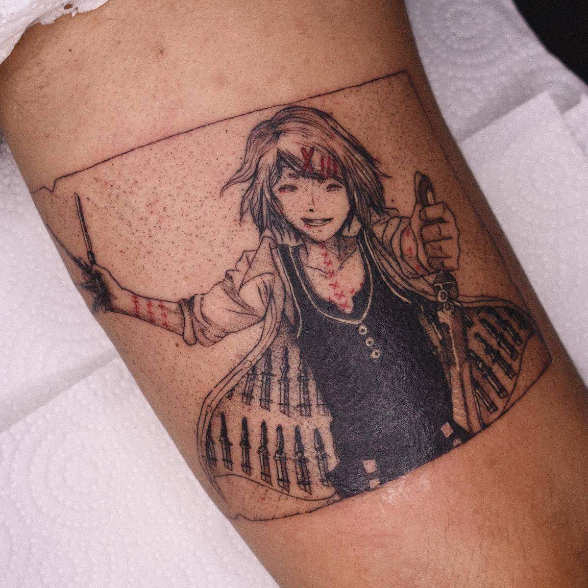 Thigh tattoo of Juuzou Suzuya from Tokyo Ghoul, showcasing his signature grin and weapon