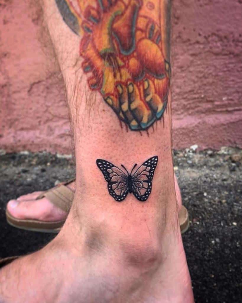 A monarch butterfly tattoo graces the ankle