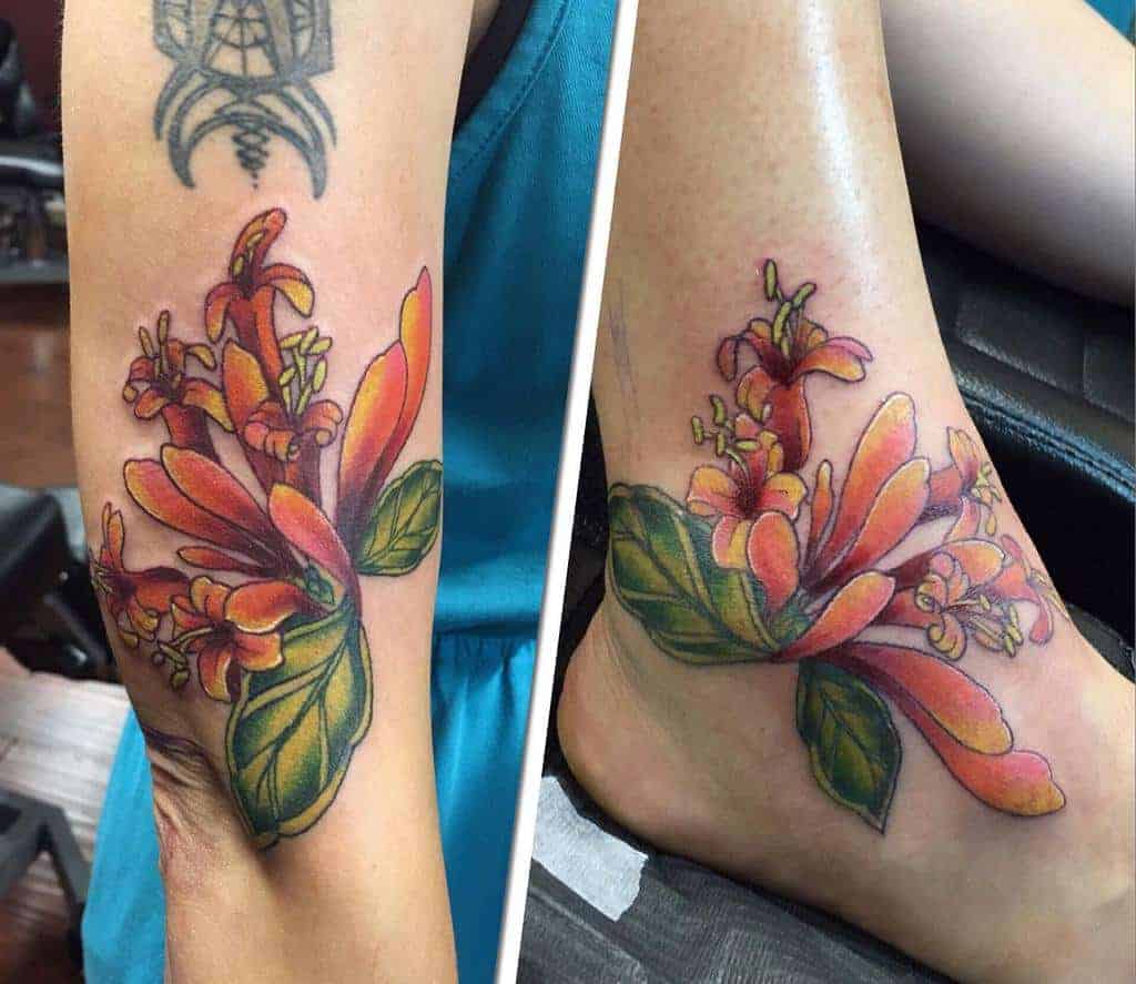 A vibrant honeysuckle tattoo on the ankle, radiating with warm hues of orange and green, showcasing nature’s beauty