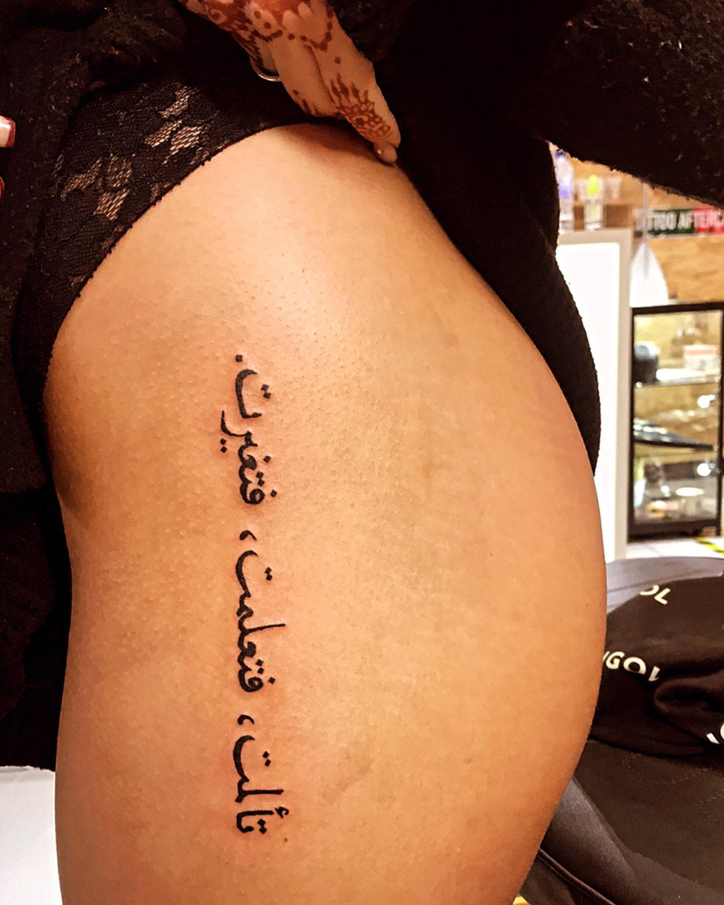 Tattoo with Arabic script on an upper thigh