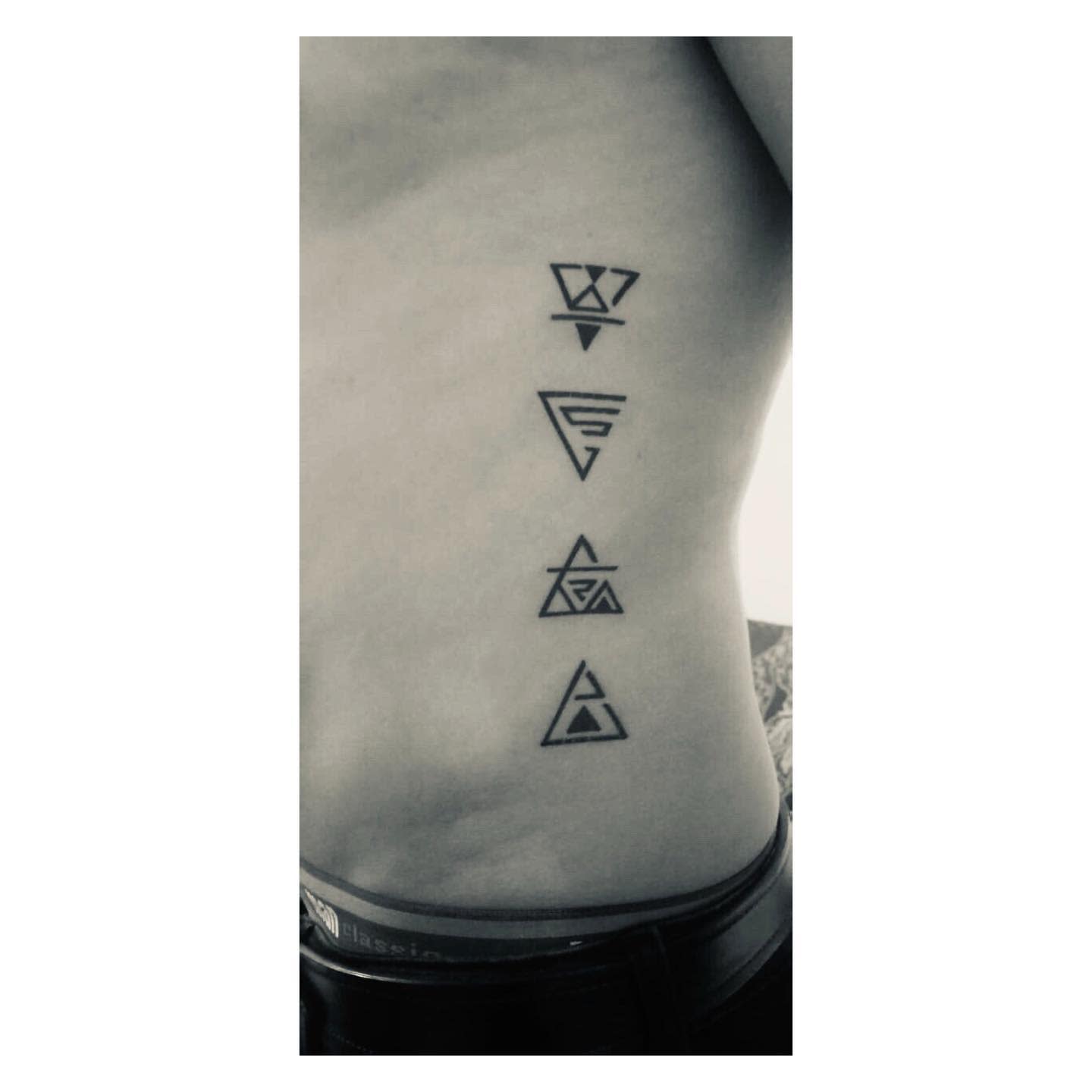 Side view featuring five vertically arranged geometric tattoos