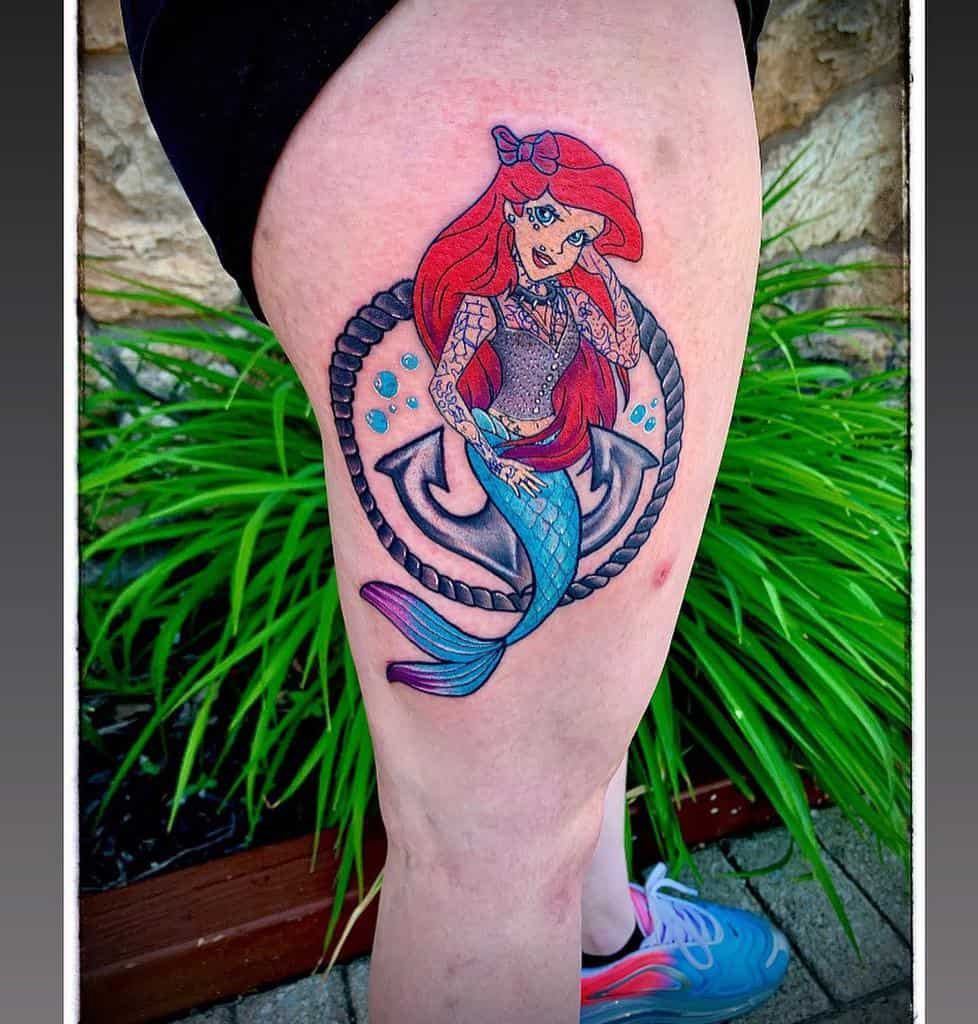 A vibrant tattoo of Ariel with a modern twist, featuring tattoos, a bow, and a nautical anchor background, accented with water droplets