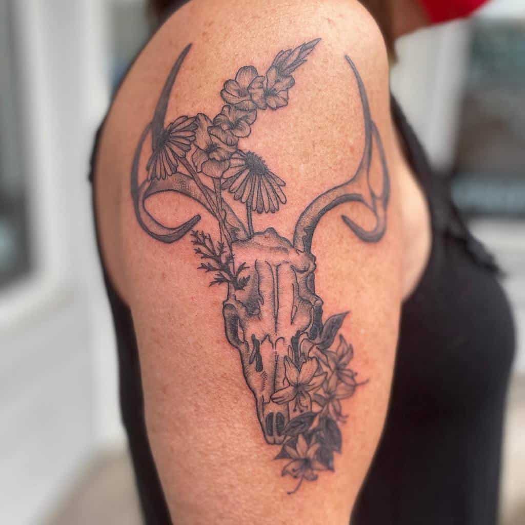 Detailed deer skull tattoo adorned with blooming honeysuckle, blending nature and resilience