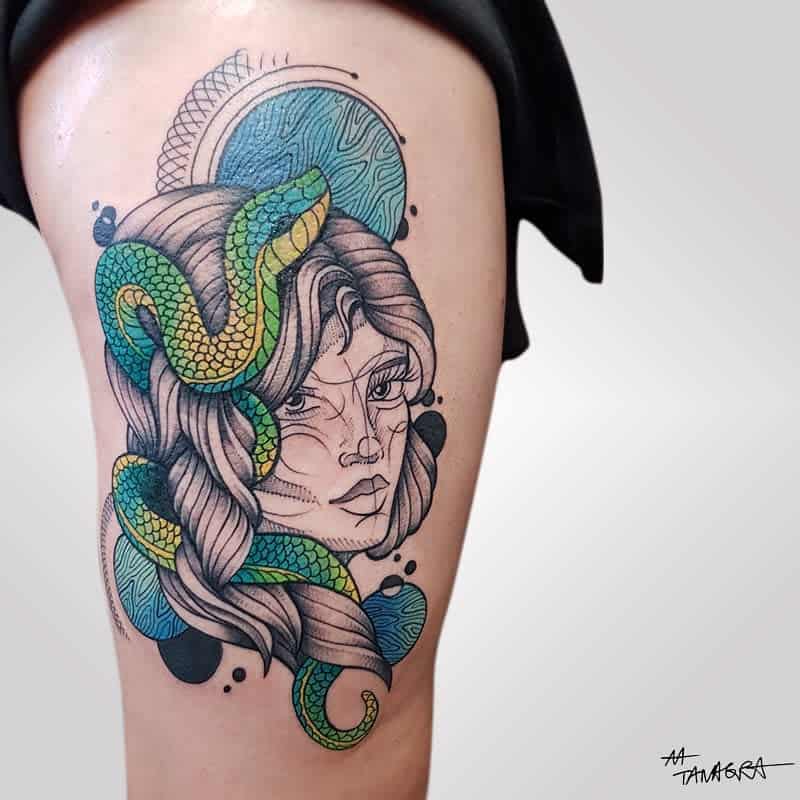 Art Nouveau tattoo of a woman's face with flowing hair, a green snake, and abstract celestial elements