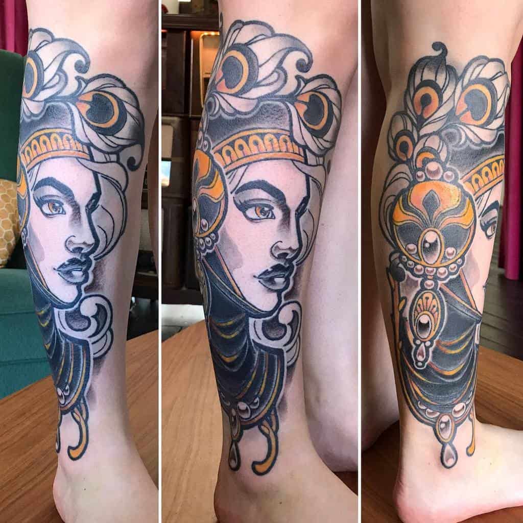 Art Nouveau tattoo of a regal woman with ornate details, flowing lines, and golden accents.