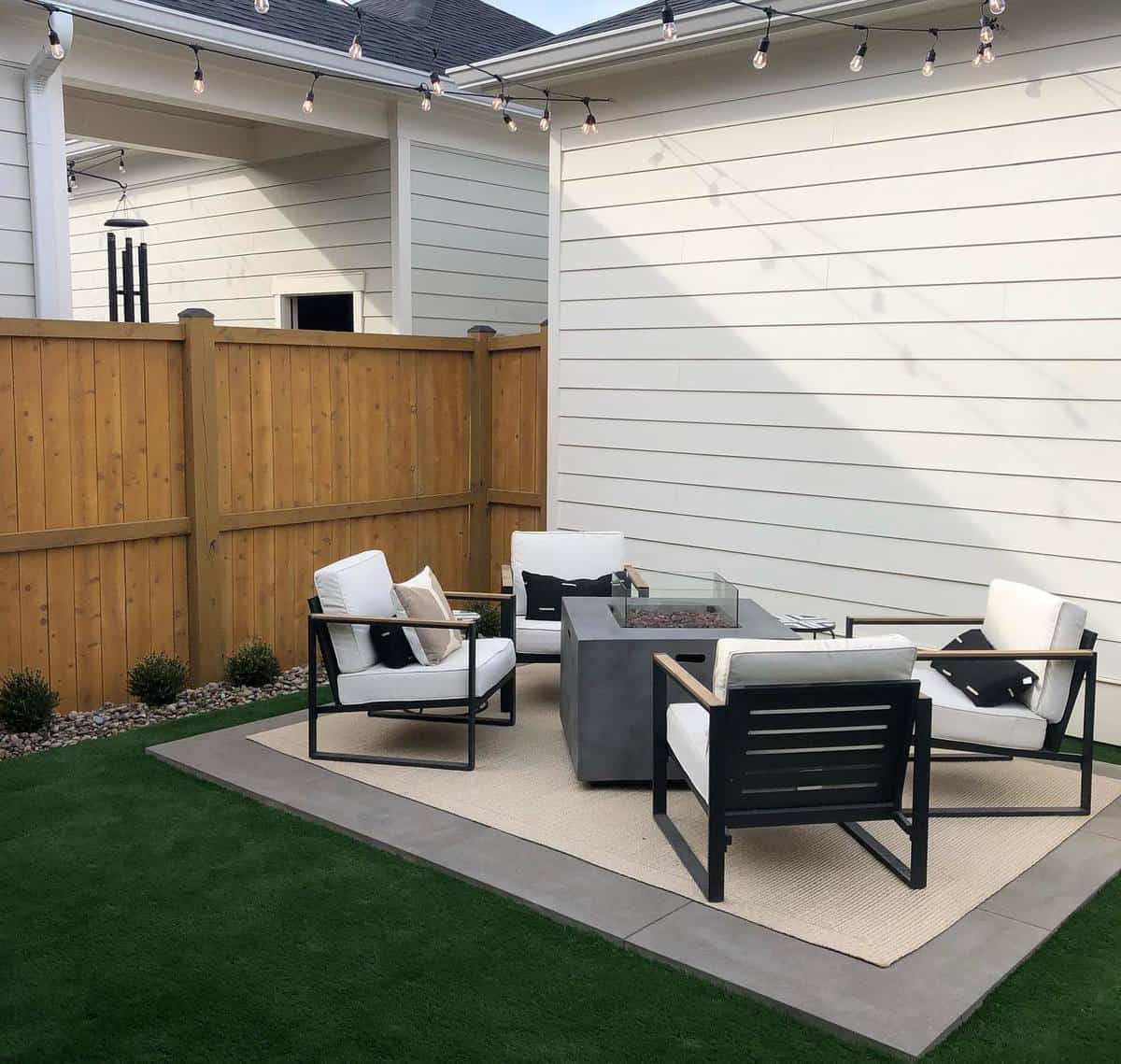 stone slate patio black outdoor furniture fire pit feature artificial grass wood fence 